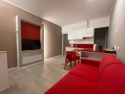 a living room with a red couch and a kitchen at Il Parco di Yuki (4) in Ancona