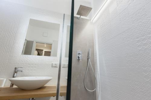 a white bathroom with a sink and a shower at Sicily Dreams Luxury in Agrigento