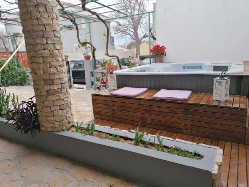 a deck with a hot tub in a backyard at Holiday Home Kotulin in Pakoštane