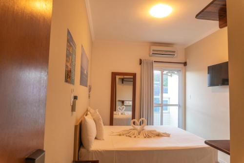 a bedroom with a bed and a mirror at UPG Hotel in Ubatuba