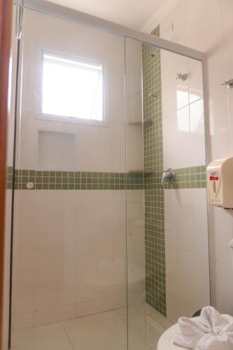 a bathroom with a shower with a glass door at UPG Hotel in Ubatuba
