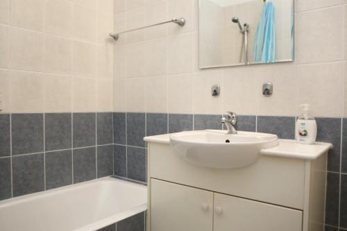 een badkamer met een wastafel en een bad bij Apartment Iris Village Kato Paphos in Paphos