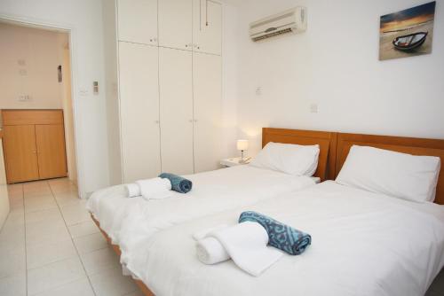 twee bedden in een slaapkamer met handdoeken erop bij Apartment Iris Village Kato Paphos in Paphos