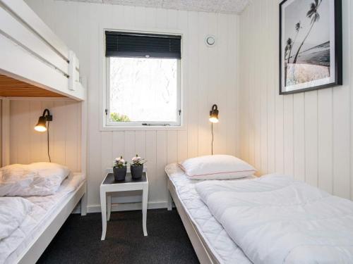 - 2 lits dans une petite chambre avec fenêtre dans l'établissement Holiday home Toftlund VIII, à Toftlund