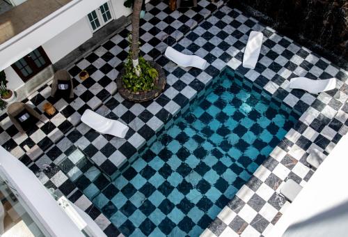 an overhead view of a pool on a checkered floor at The Xperience by g in Mazatlán