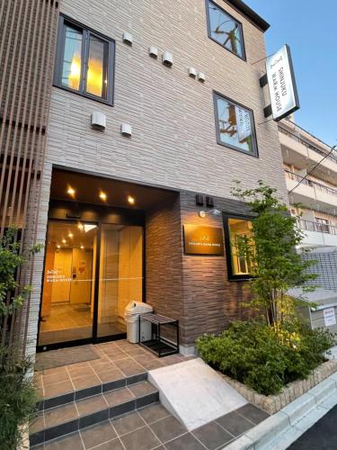a building with a walkway in front of it at SHINJUKU WARM HOUSE in Tokyo