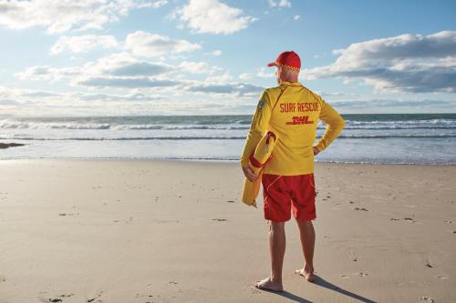 a man standing on the beach with a life vest on at Surfers Beachside Holiday Apartments in Gold Coast