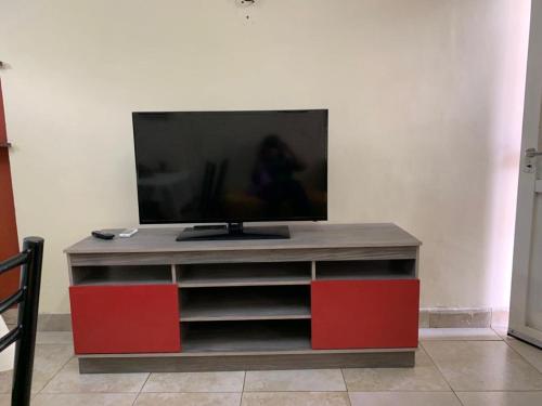 einen Flachbild-TV auf einem roten Entertainment-Center in der Unterkunft Multiespacio Turismo-Trabajo Av Entre Ríos in Salta