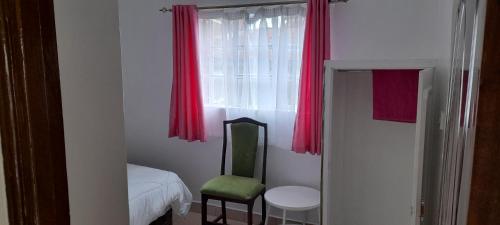 Habitación con ventana con silla y mesa en DENOBASE MILIMANI, en Nairobi
