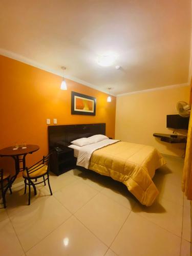 a bedroom with a bed and a table in it at Royal Garden Hotel in Lima