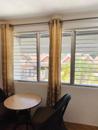 a table and chairs in a room with windows at Maharajah Hotel in Angeles