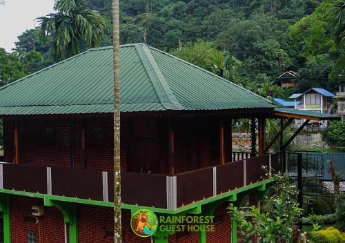 a building with a green roof on top of it at Rain Forest Guest House and Jungle Trekking in Bukit Lawang