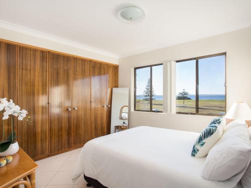 a bedroom with a bed and a large window at Villa Bianca 10 opposite the Tanks in Forster