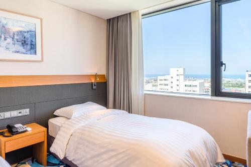 Postel nebo postele na pokoji v ubytování Shin Shin Hotel Jeju Airport