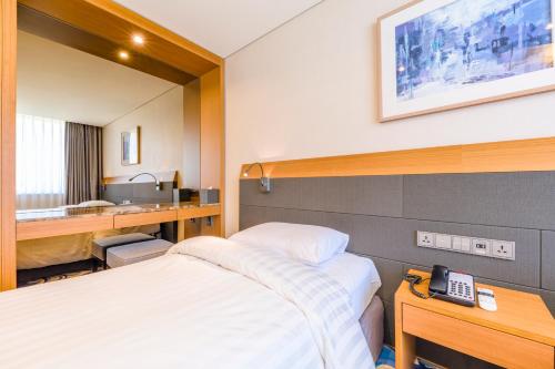 Postel nebo postele na pokoji v ubytování Shin Shin Hotel Jeju Airport