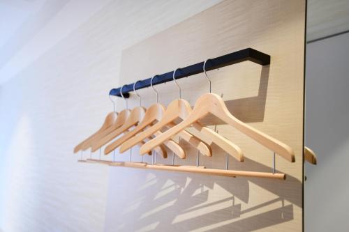 a row of wooden hangers on a wall at IAM HOTEL in Osaka