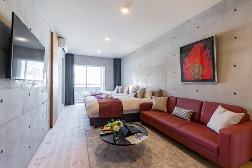 a bedroom with a bed and a red couch at Tamatsukuri Daifuji Kan in Osaka