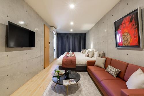 a hotel room with a bed and a couch at Tamatsukuri Daifuji Kan in Osaka