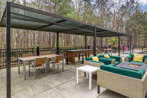 a pergola with tables and couches on a patio at Holiday Inn Atlanta-Gas South Arena Area by IHG in Duluth