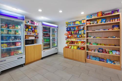a store aisle with refrigerators and shelves of food at Holiday Inn Express Detroit-Warren/General Motors Technology Center by IHG in Warren