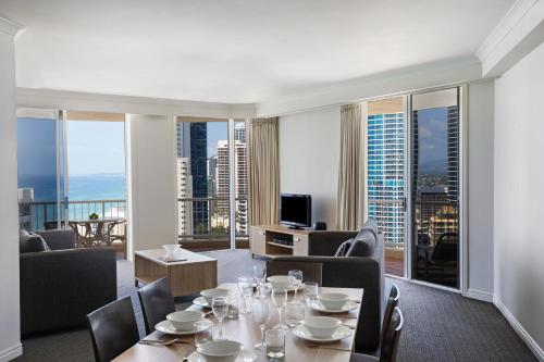 a living room with a table and chairs and a large window at BreakFree Moroccan in Gold Coast