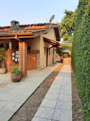 a walkway next to a house with a hedge at Residencial Maresias Suites e Chalés in Maresias