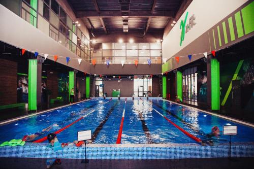 a large indoor swimming pool with people in it at Baikal Forest Hotel in Irkutsk