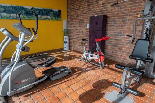 a gym with two exercise bikes and a brick wall at GHL Style Yopal in Yopal