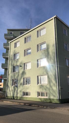 a large green building with the sun shining on it at Cosy apartment in the city center in Kemi