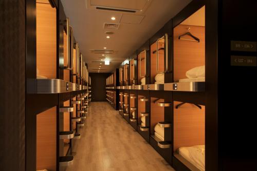 a row of bunk beds in a room at TUBE Sq in Tokoname