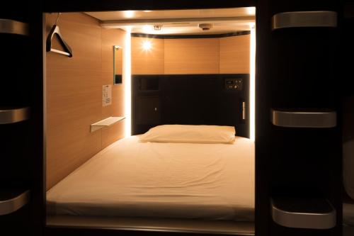 a small bedroom with a bed in a room at TUBE Sq in Tokoname