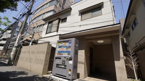 a vending machine in front of a building at House Ikebukuro in Tokyo