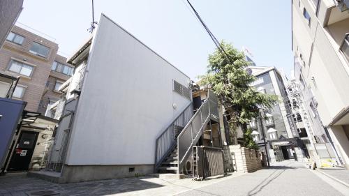 a building with a staircase in the middle of a street at House Ikebukuro in Tokyo