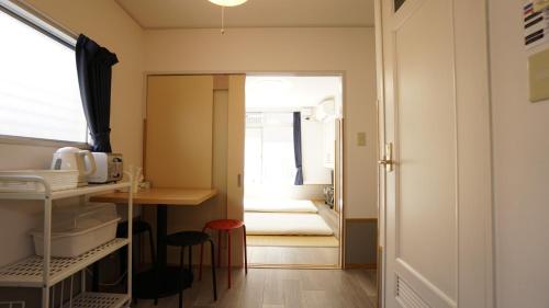a kitchen with a door open and a door open at House Ikebukuro in Tokyo