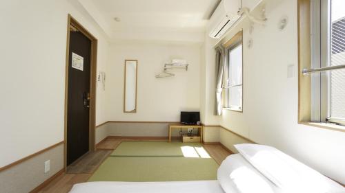 a hospital room with a bed and a window at House Ikebukuro in Tokyo