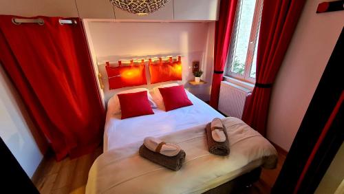 a small bedroom with two beds with red pillows and shoes at Villa Kady - Chalet de charme du 19ième siécle in Le Touquet-Paris-Plage