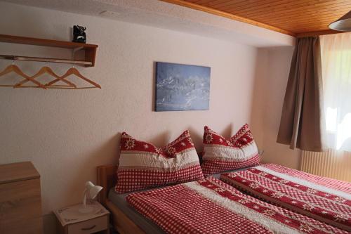 a bedroom with two beds with red and white pillows at Harri's BnB in Kandersteg, Ferienwohnung in Kandersteg