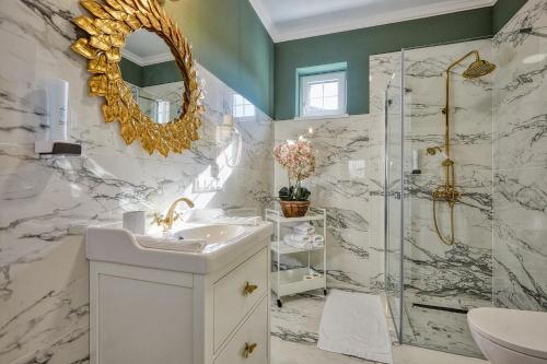 a bathroom with a shower and a sink and a mirror at The Doors Boutique Apartments in Mosonmagyaróvár