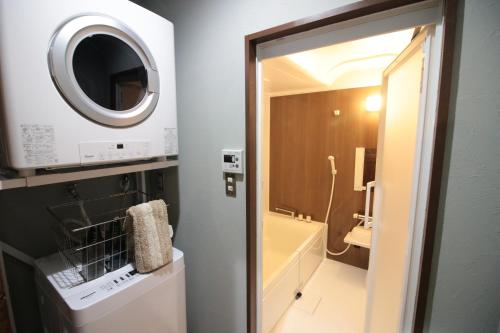 a bathroom with a sink and a microwave at Plus Life Ishigaki in Ishigaki Island