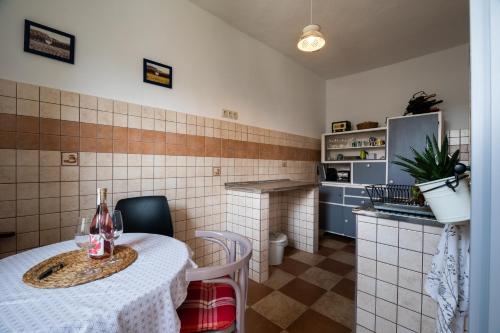 eine kleine Küche mit einem Tisch, einem Tisch und Stühlen in der Unterkunft Miliő Apartman Badacsony in Badacsonytördemic