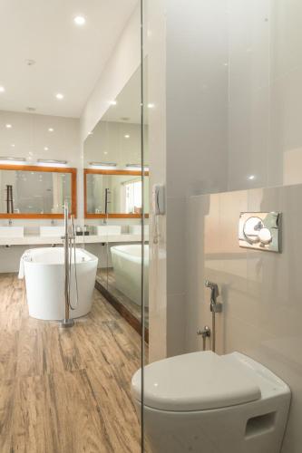 a bathroom with a tub and a toilet and a sink at Shinagawa Beach in Balapitiya