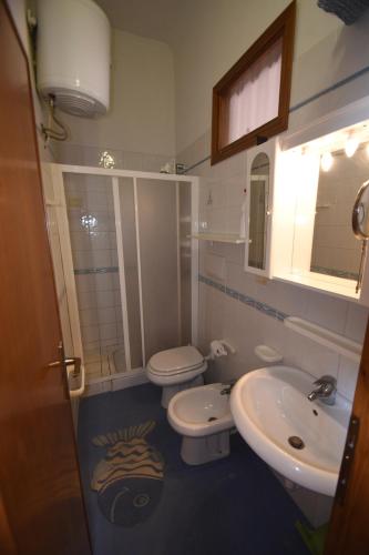 a bathroom with a toilet and a sink at Bilocali ALTAMAREA - zona mare con clima e terrazze in Marina di Campo