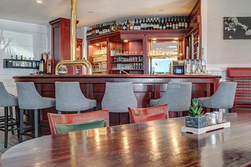 a restaurant with a wooden bar with chairs and a table at Hotel Stadt Mühlhausen in Mühlhausen