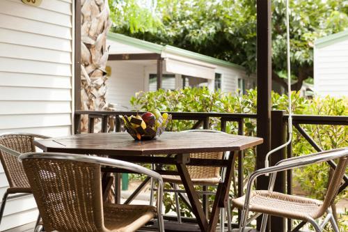 
a bird sitting on a wooden table in front of a patio at Camping Platja Cambrils in Cambrils
