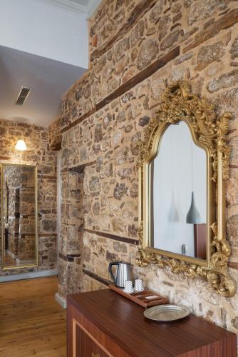 a stone wall with a mirror and a wooden table at Delight Deluxe Hotel in Antalya