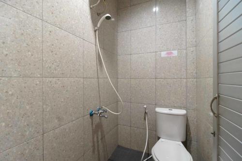 uma casa de banho com chuveiro e WC em RedDoorz near RS Adam Malik Medan 2 em Sunggal