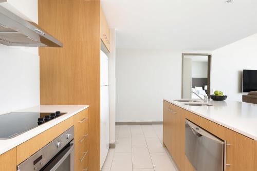 a kitchen with a sink and a stove top oven at Mantra Twin Towns in Tweed Heads