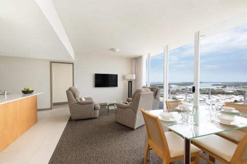 a living room with a table and chairs and a television at Mantra Twin Towns in Tweed Heads