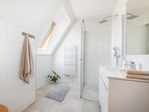 a white bathroom with a shower and a sink at Anielska Osada in Groń