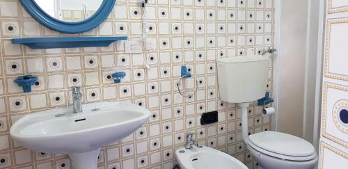 W łazience znajduje się umywalka, toaleta i lustro. w obiekcie Casa Maria w mieście Levanto